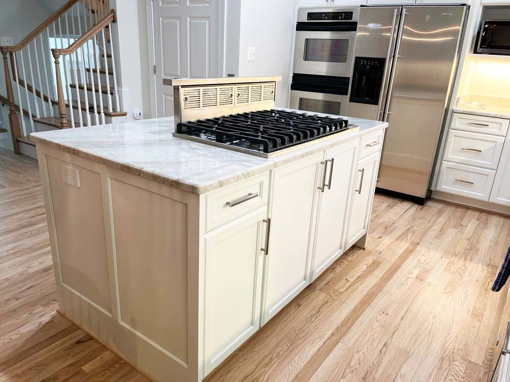Kitchen island with gas cooktop and marble countertop by Anchor Remodel in McLean, VA.