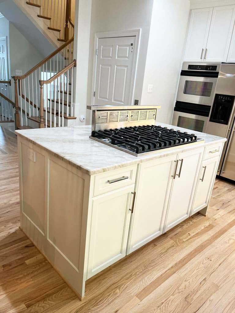 Kitchen island with retractable downdraft vent and cooktop by Anchor Remodel in McLean, VA.