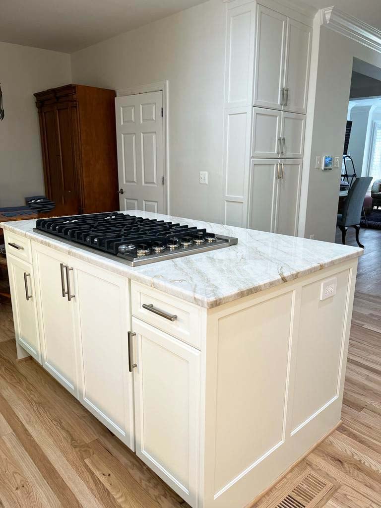 White shaker island and stainless cooktop in custom kitchen remodel by Anchor Remodel in McLean, VA.