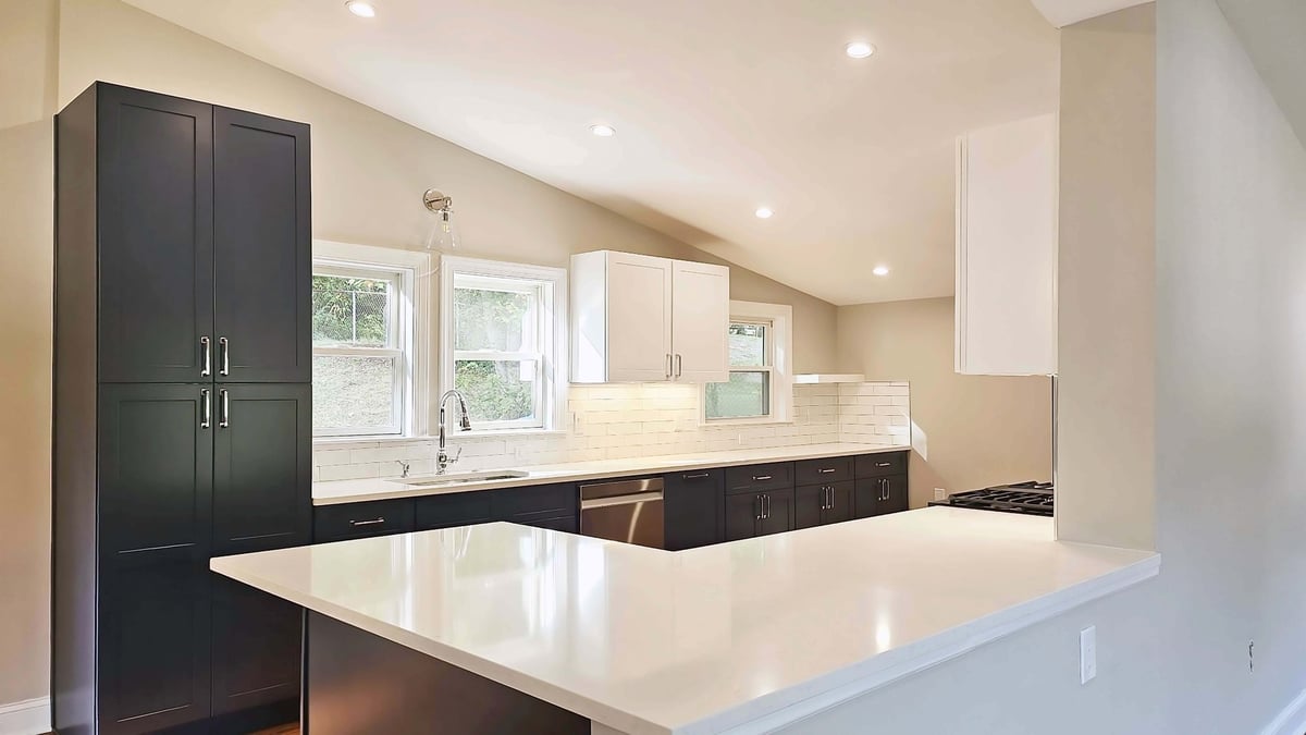 Wide view of kitchen renovation with sleek cabinetry and large prep surfaces by Anchor Remodel in Alexandria, VA.