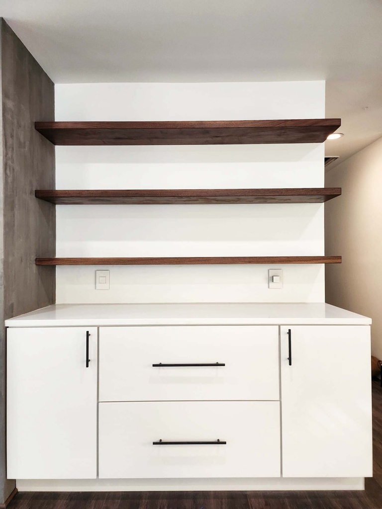 Built-in storage area with open wood shelving and white cabinets by Anchor Remodel in Alexandria, VA.