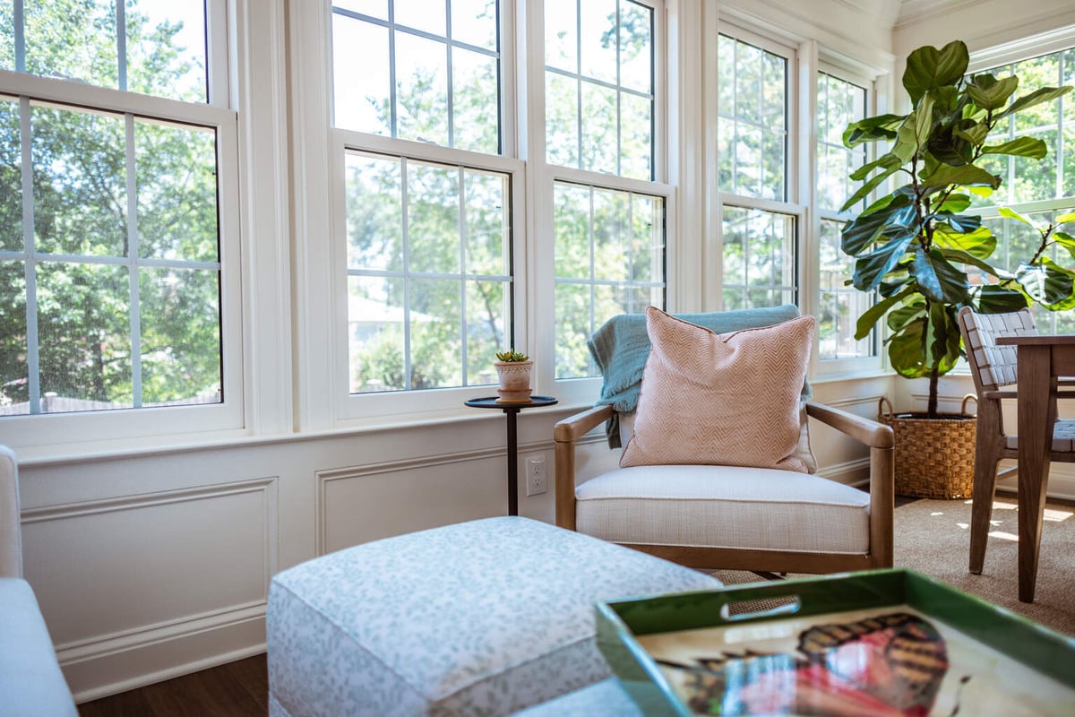 Interior view of custom sunroom corner with chair and pillows by Anchor Remodel in Alexandria, VA