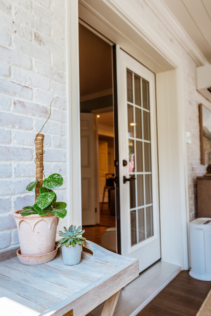 Succulent plants on wooden table near glass door in sunroom by Anchor Remodel in Alexandria, VA