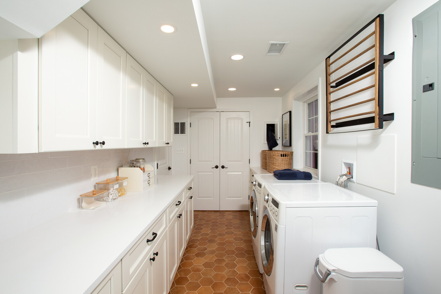 White cabinetry and washer-dryer setup in custom laundry room by Anchor Remodel in Vienna, VA.
