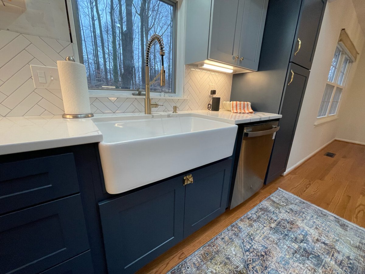 Close-up of farmhouse sink and brushed gold faucet in Springfield kitchen remodel by Anchor Remodel.
