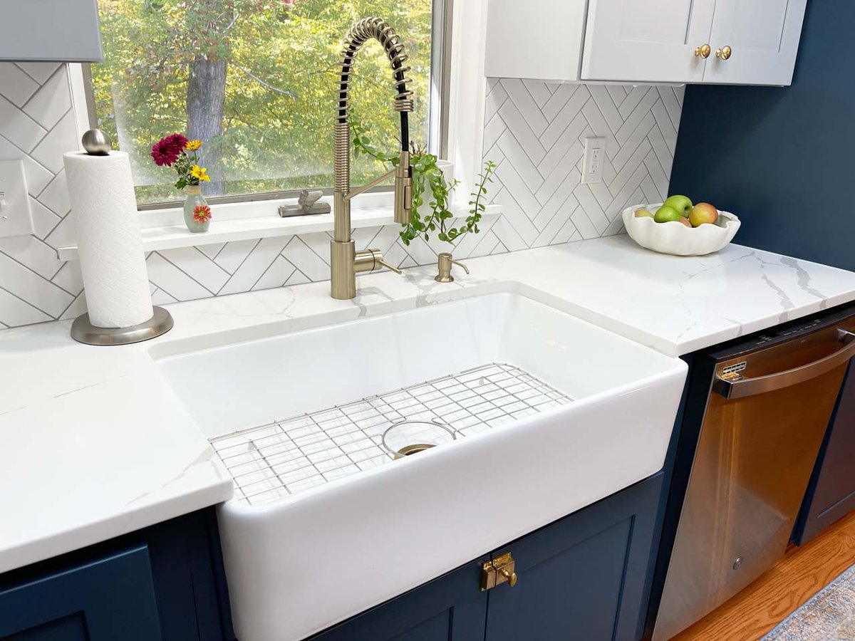 Elegant sink area with white countertops and large window by Anchor Remodel in Springfield, VA.