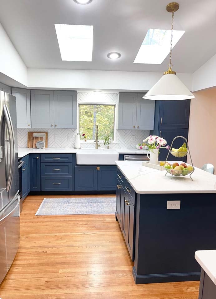 Open kitchen with skylights and navy cabinets by Anchor Remodel in Springfield, VA.