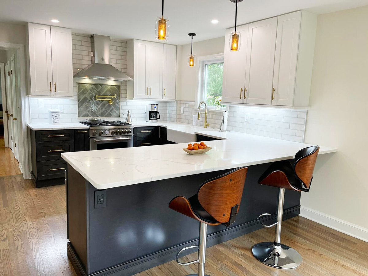 Bright kitchen featuring modern island seating and black base cabinetry by Anchor Remodel in Alexandria, VA