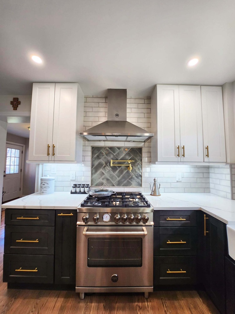 Central gas range with modern hood and backsplash by Anchor Remodel in Alexandria, VA