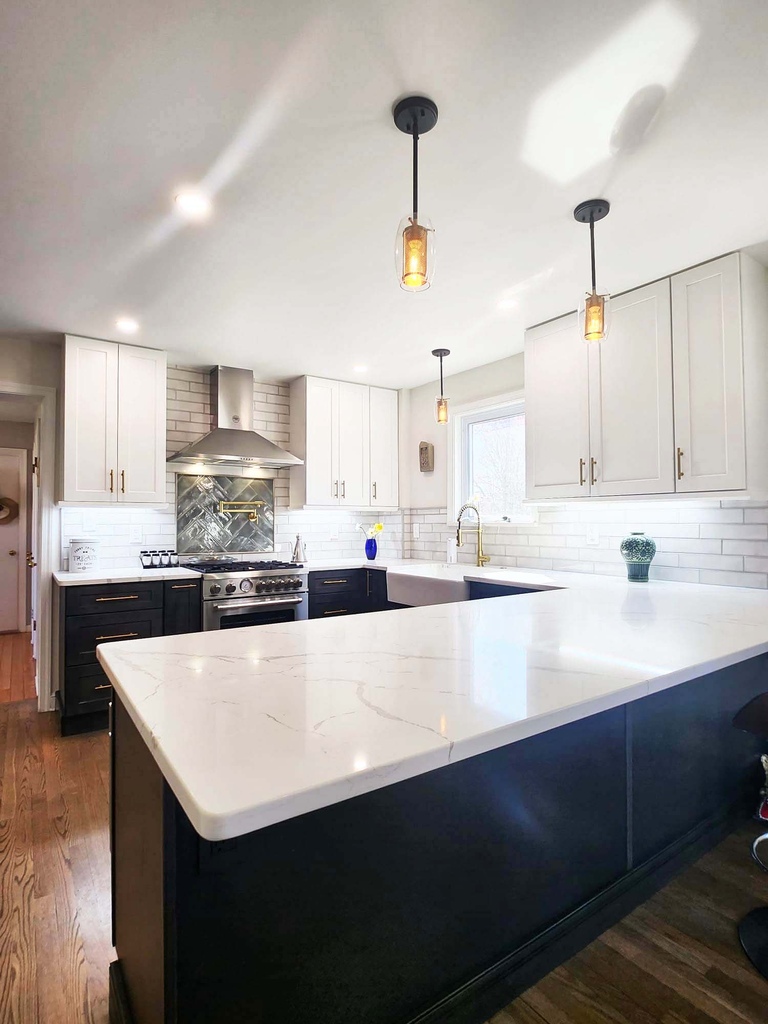Quartz waterfall island and pendant lights in custom kitchen by Anchor Remodel in Alexandria, VA
