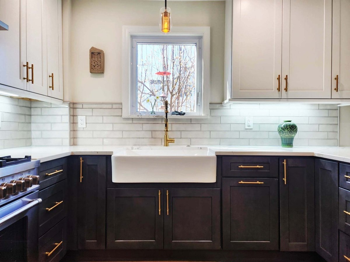 White and black cabinet design with gold hardware in custom kitchen by Anchor Remodel in Alexandria, VA