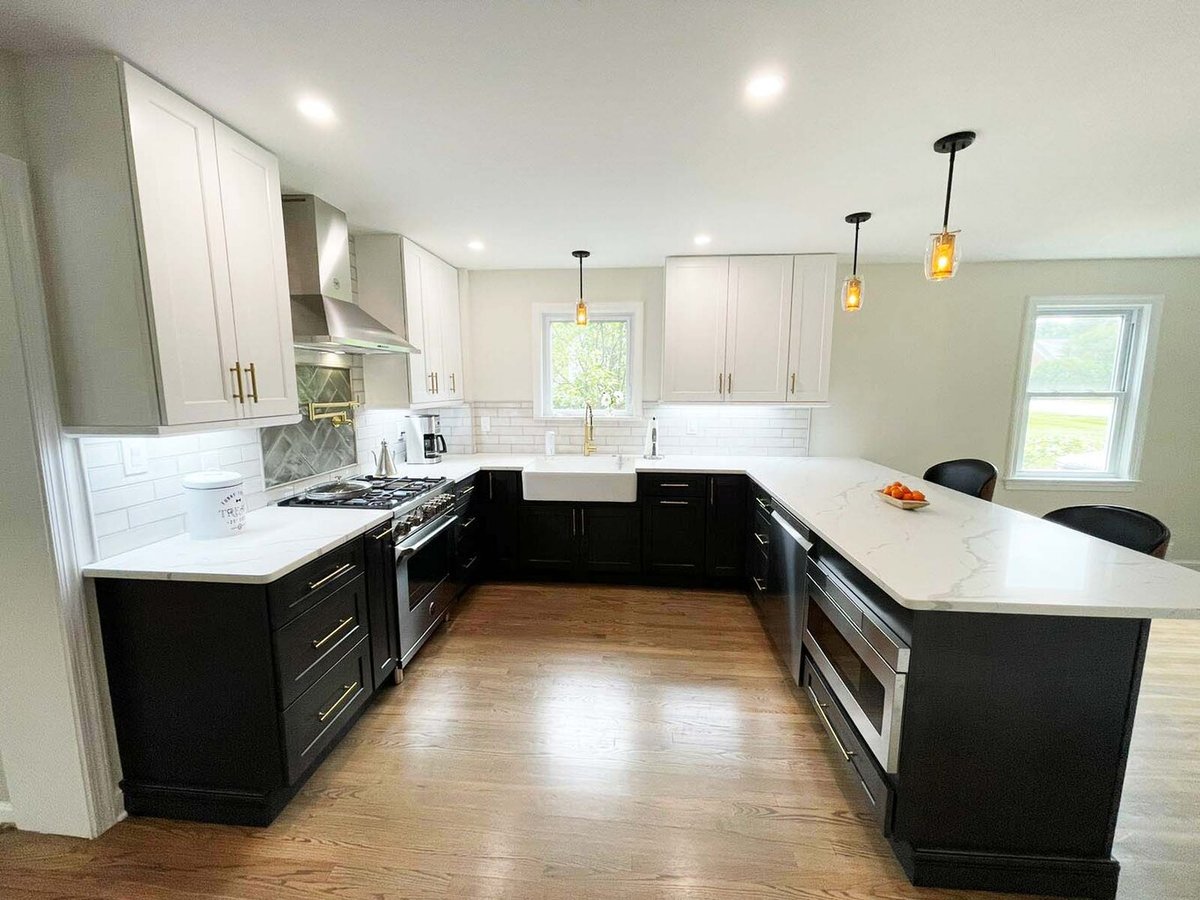 Wide-angle view of kitchen with quartz countertops and white uppers by Anchor Remodel in Alexandria, VA