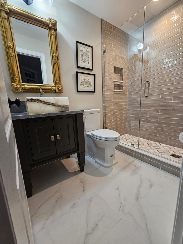 Elegant powder room with gold-framed mirror and custom vanity in Leesburg by Anchor Remodel.