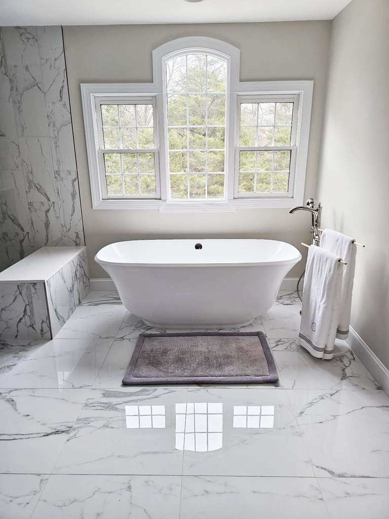 Leesburg master bathroom remodel with freestanding tub and arched window by Anchor Remodel.