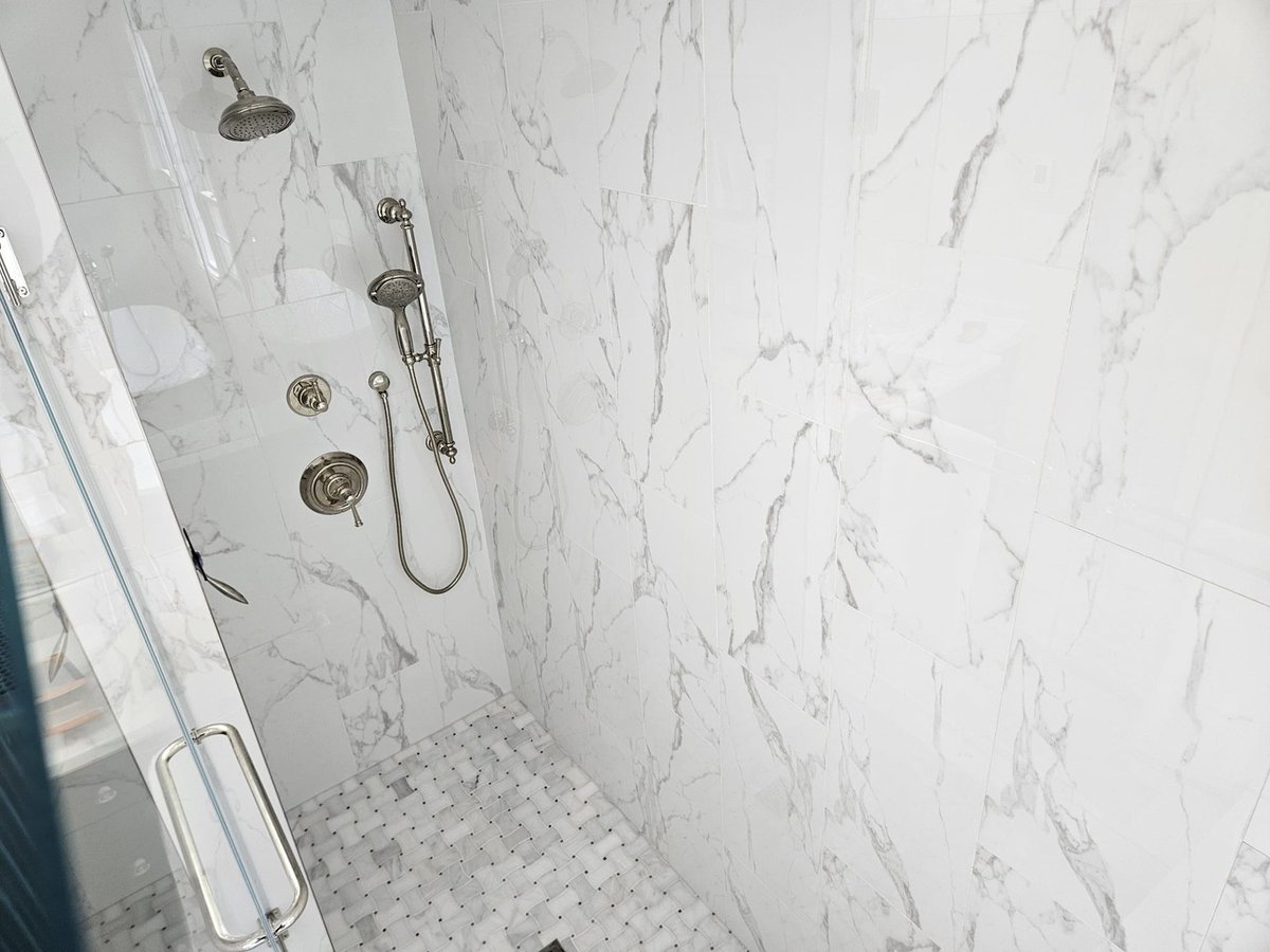 Luxurious shower remodel with chrome hardware and marble tiles in Leesburg by Anchor Remodel.