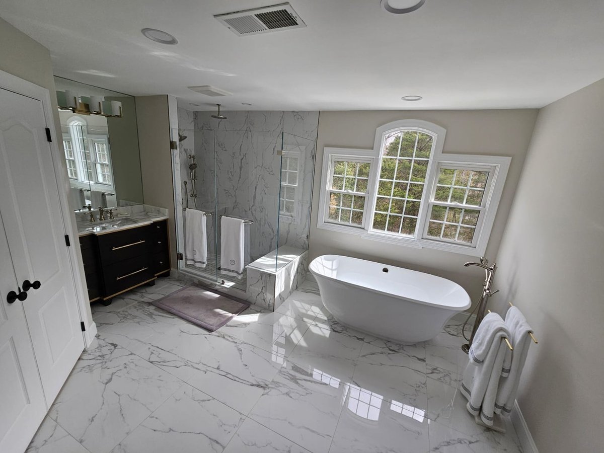 Overhead angle of modern master bath with marble tile and soaking tub in Leesburg by Anchor Remodel.