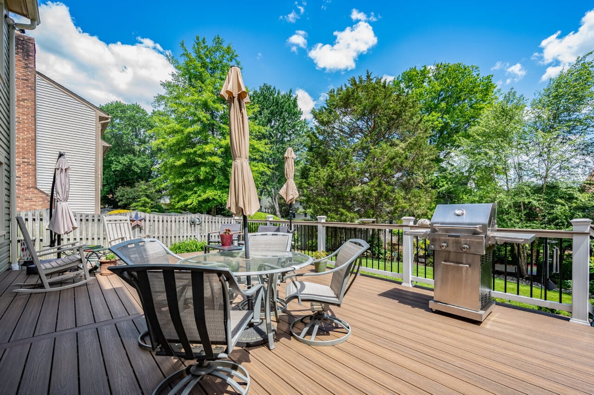 Deck in Alexandria, VA featuring Trex composite decking, outdoor dining area, stainless steel grill, and backyard views.