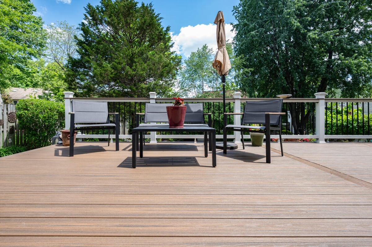 Custom Trex deck renovation in Alexandria, VA with low-maintenance composite decking, black aluminum balusters, and outdoor conversation seating.