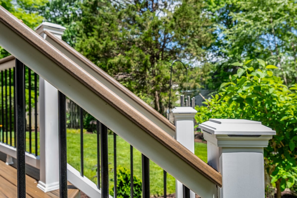 Modern Trex deck railing system in Alexandria, VA featuring white posts, black balusters, and integrated post caps
