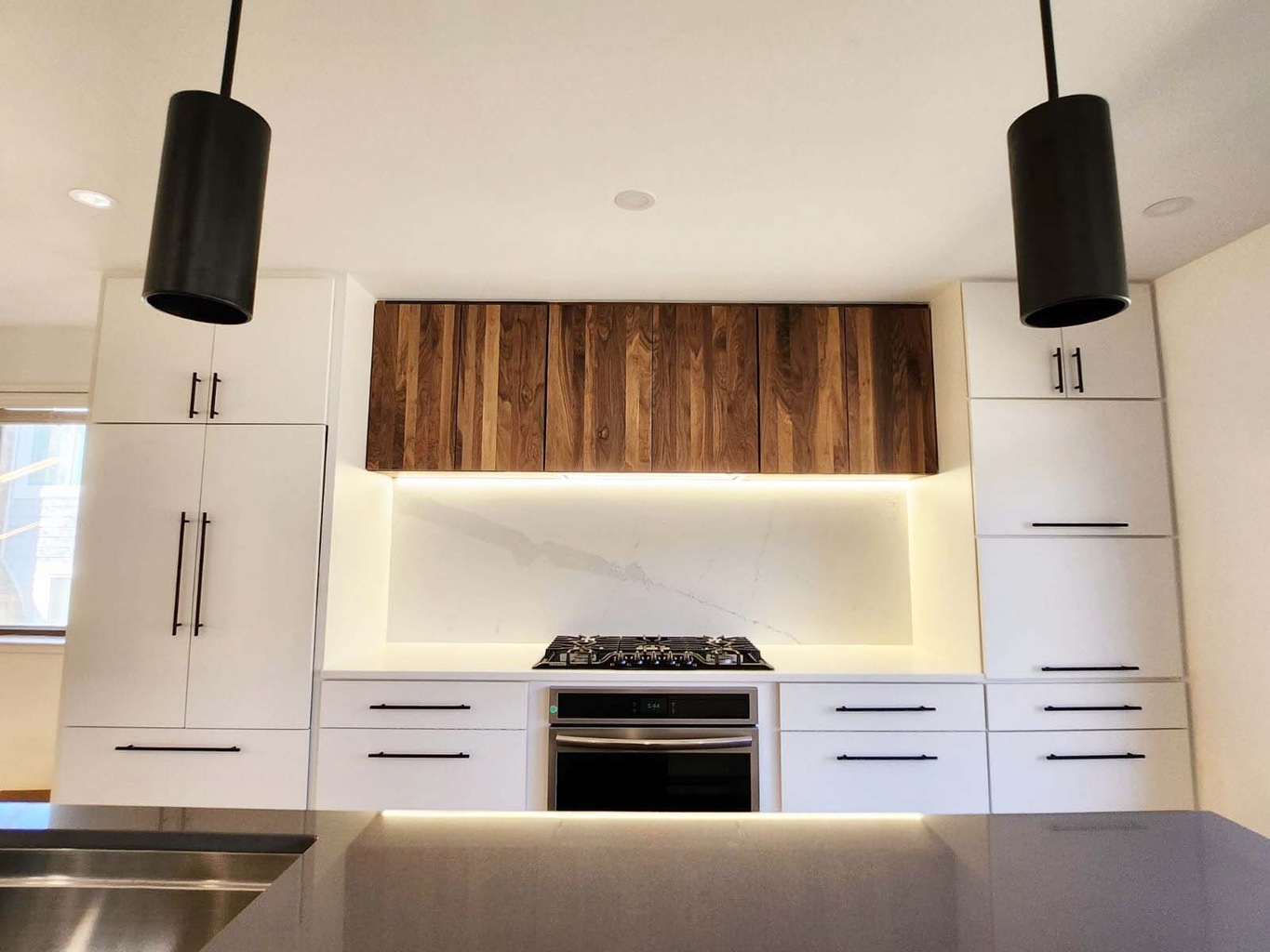 Anchor Remodel kitchen design featuring natural wood upper cabinets and black accents in Alexandria, VA.