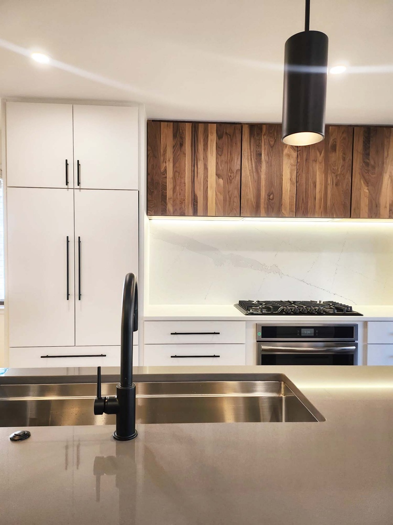 Kitchen sink with black faucet and wood-accented cabinetry by Anchor Remodel in Alexandria, VA.