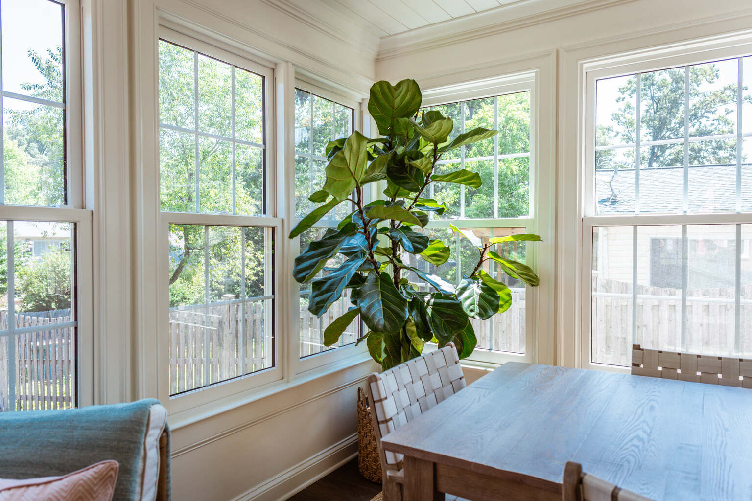 Indoor plant and wooden table in sunroom addition by Anchor Remodel in Alexandria, VA
