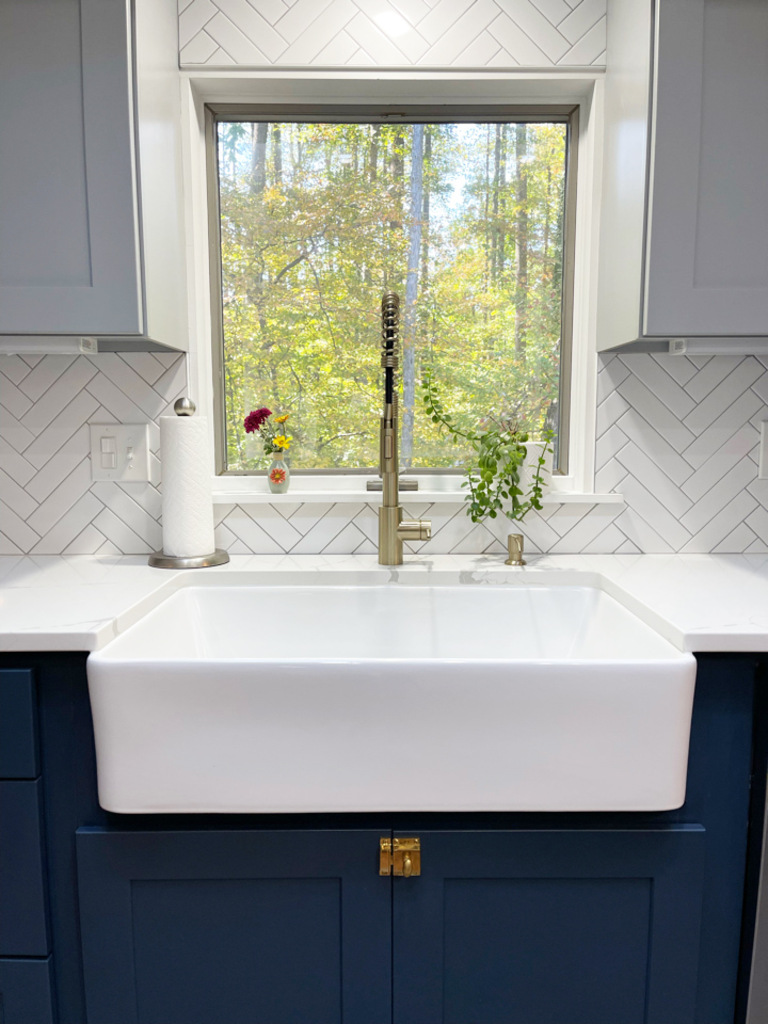 Farmhouse sink under window with herringbone tile backsplash in Springfield custom kitchen by Anchor Remodel.