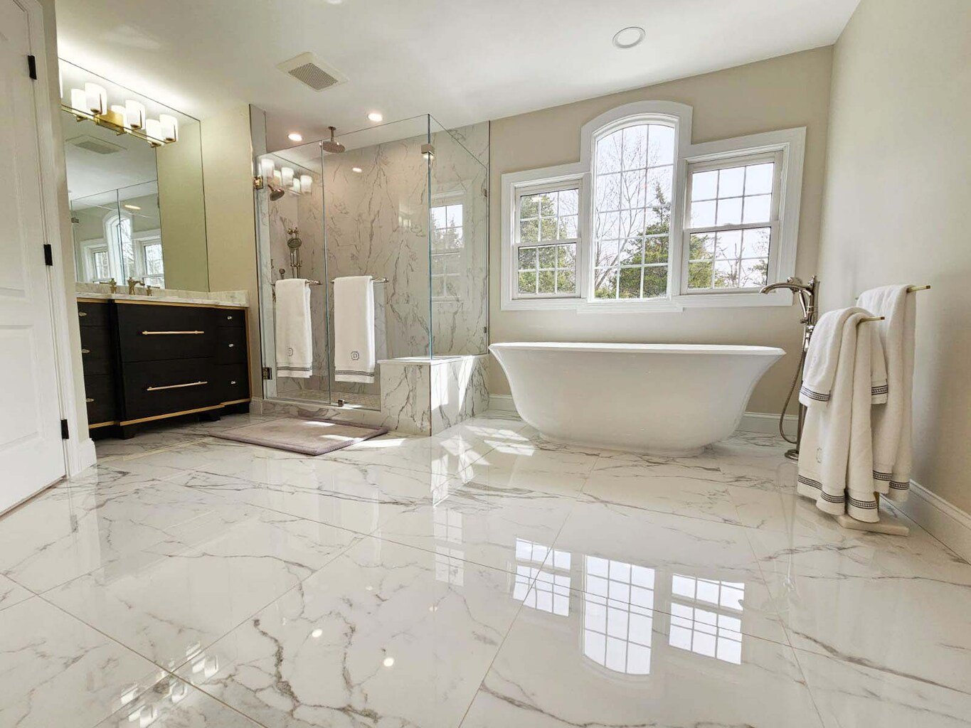 Spacious Leesburg bathroom remodel with soaking tub, dual vanities, and marble floors by Anchor Remodel.