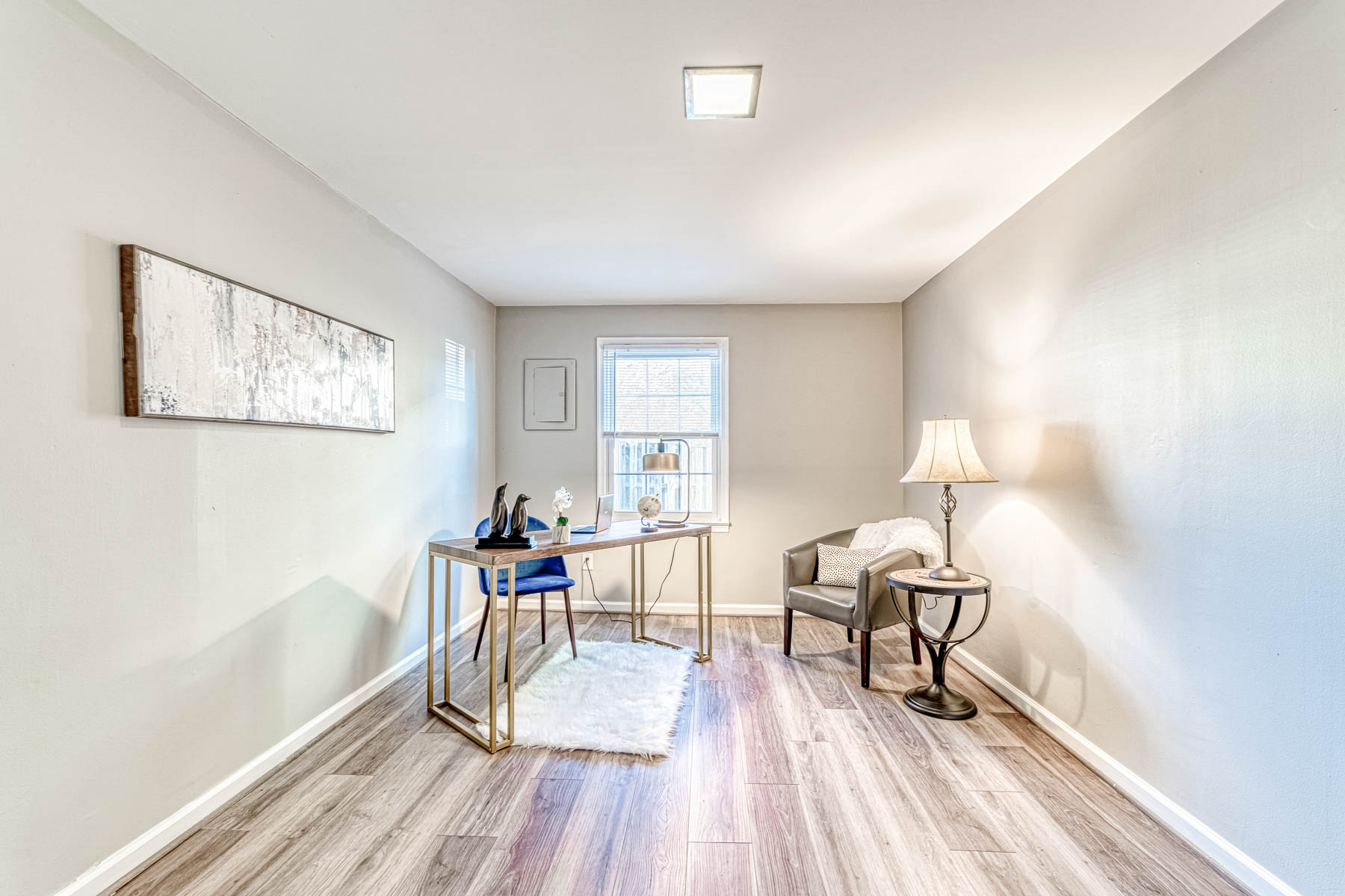 Bright home office with a modern desk, comfortable chair, large window, and elegant decor.